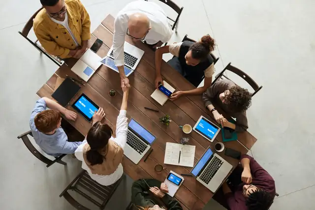 Team collaboration around a table with laptops for career selection assessment